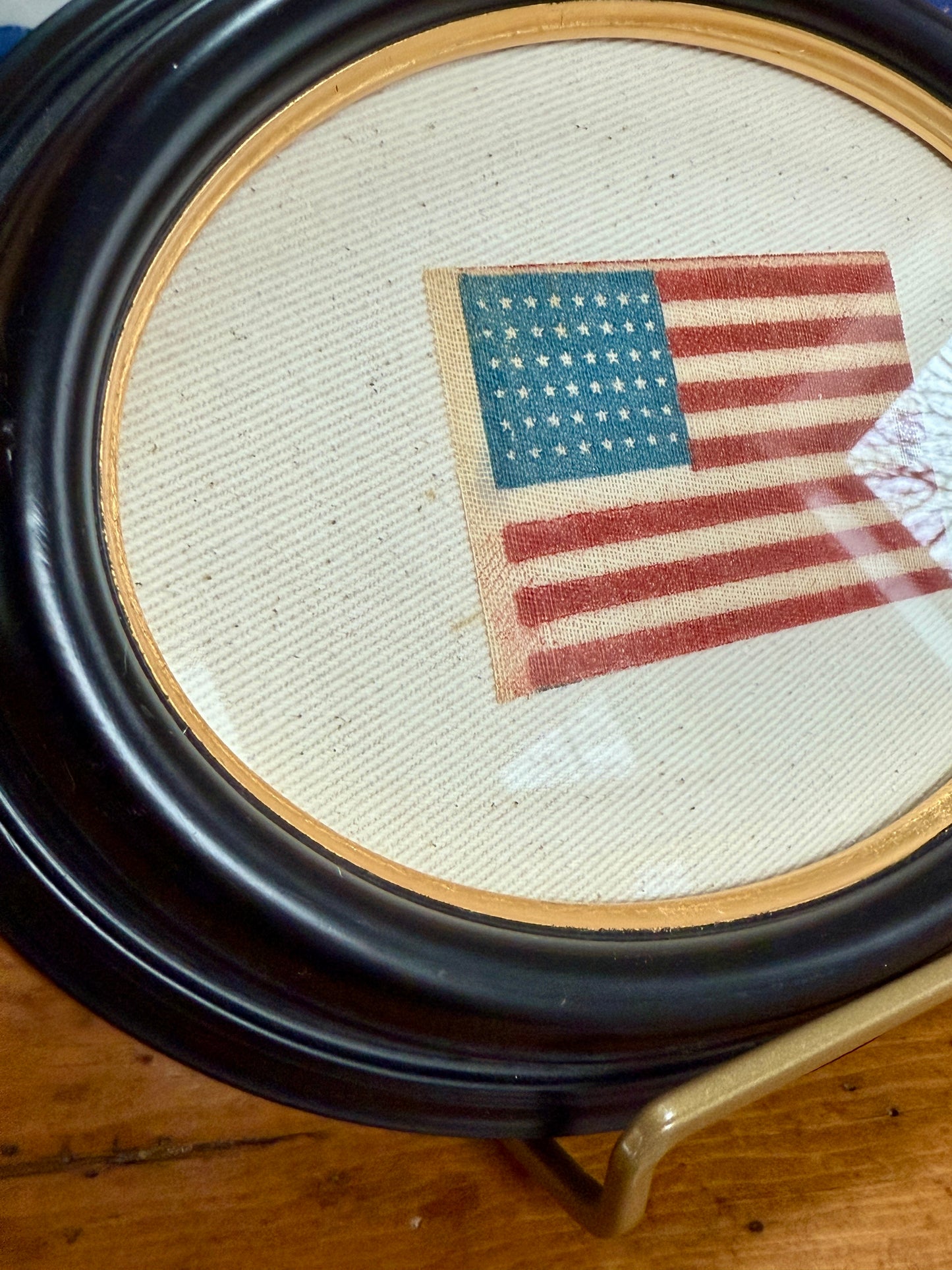 Antique 48 Star Parade Flag on Ivory Twill in Gilded Thick Black Oval Frame